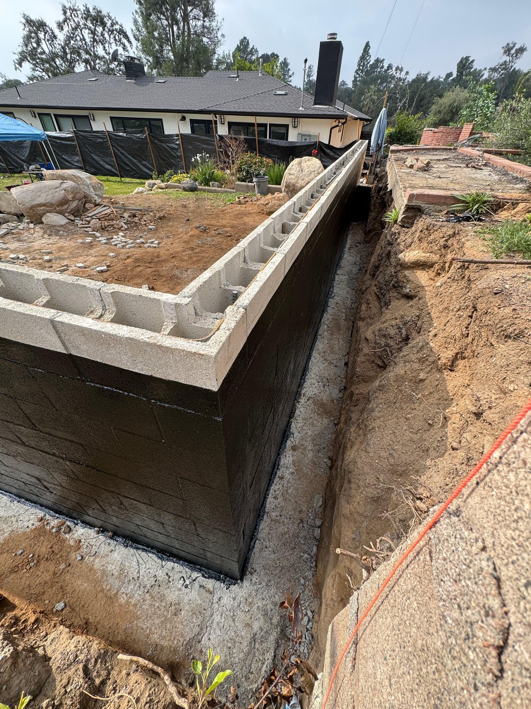 Retaining wall built from concrete block along a sloped section of the yard