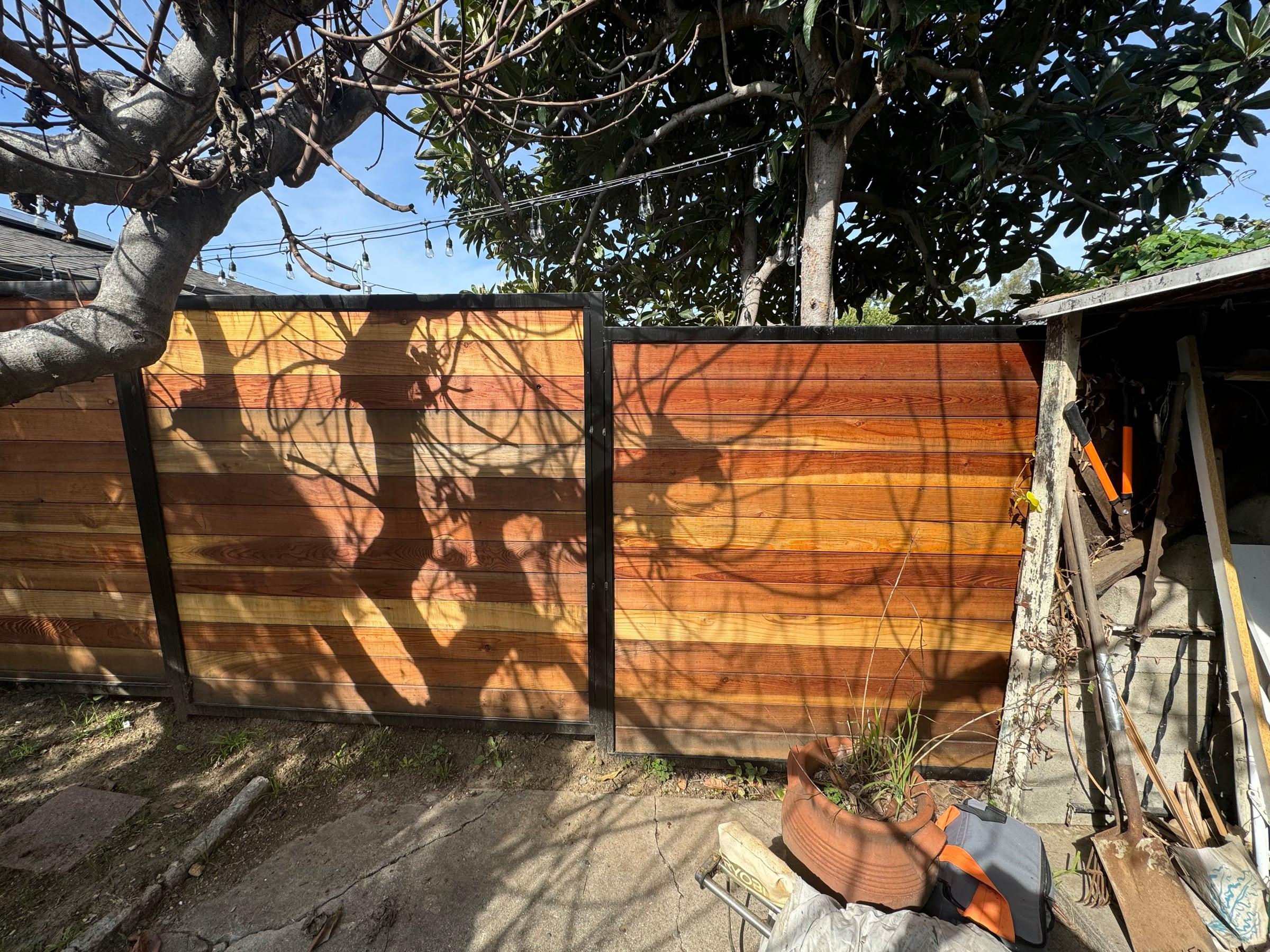 Horizontal wood fence panel with black metal frame