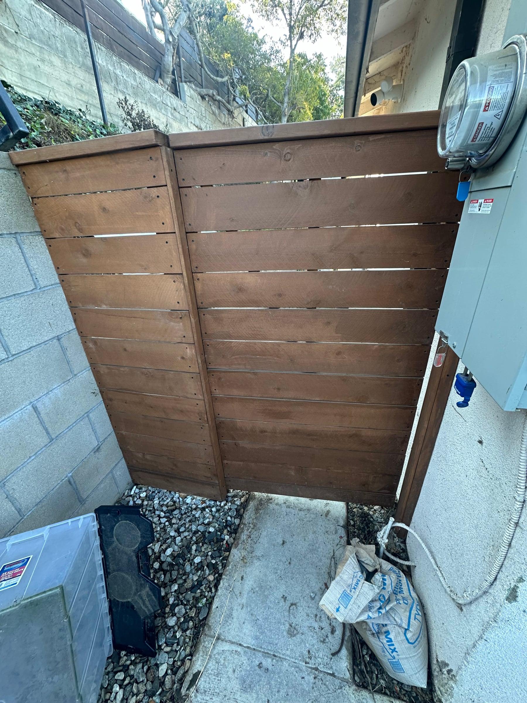 Horizontal wood gate shielding a utility meter