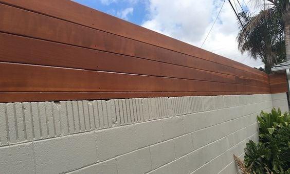Horizontal wood fence extension atop a painted block wall