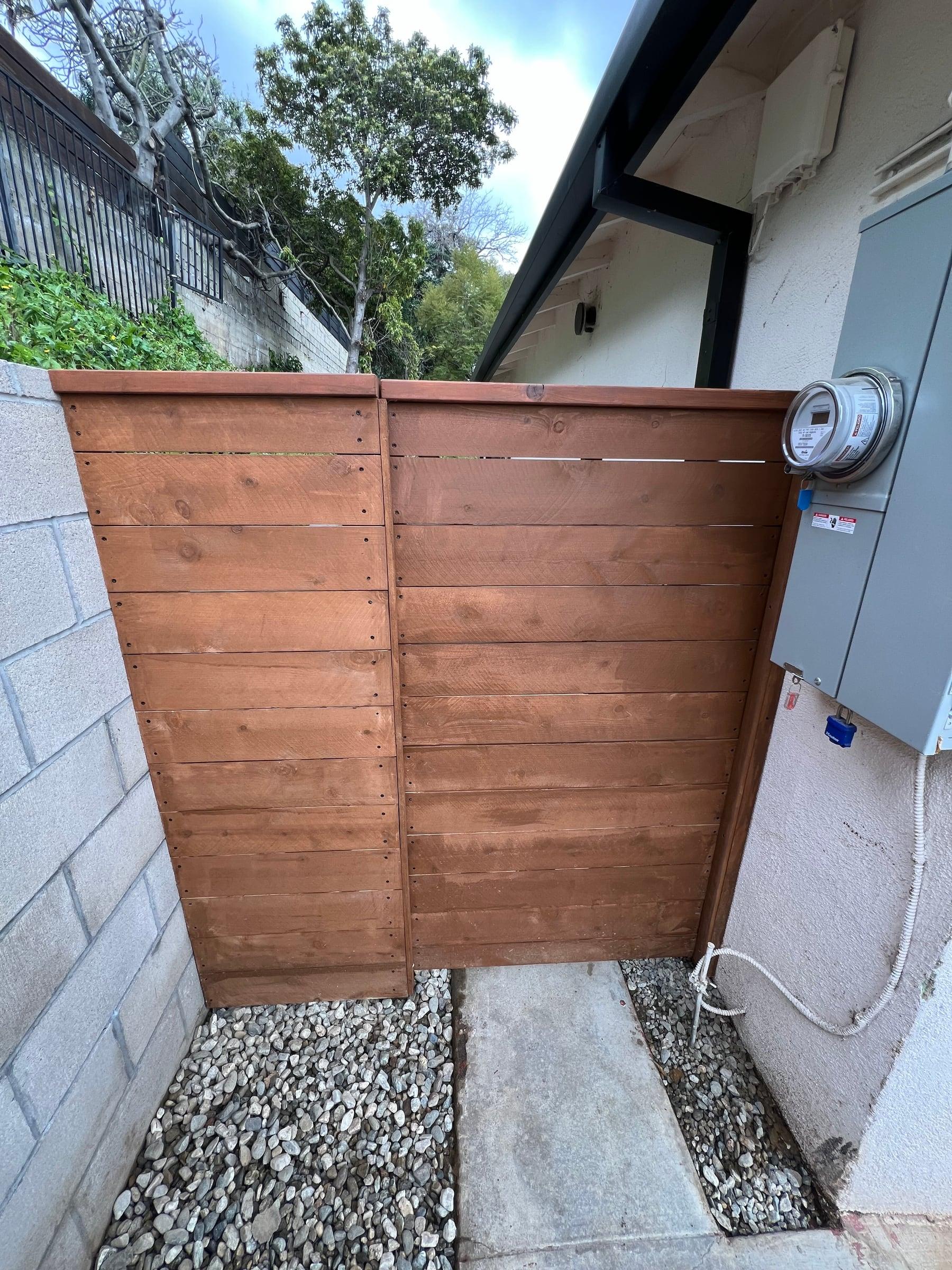 Wood gate and fence panel concealing a utility meter