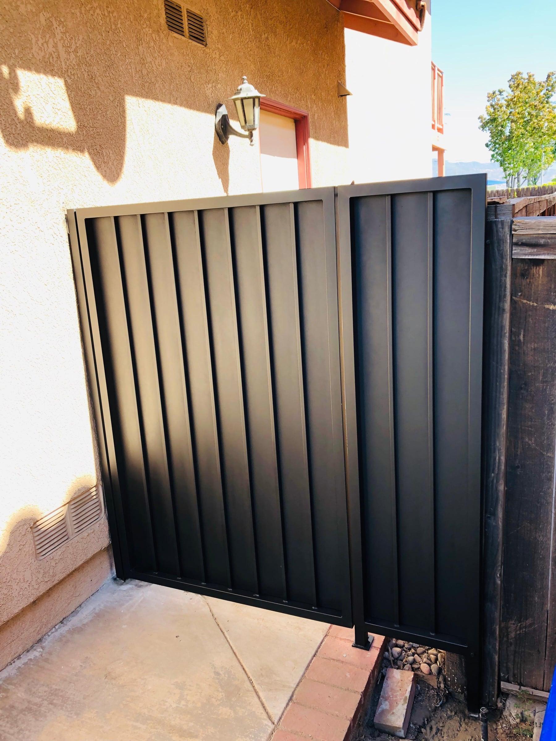 Custom iron fence panel installed along a garden pathway