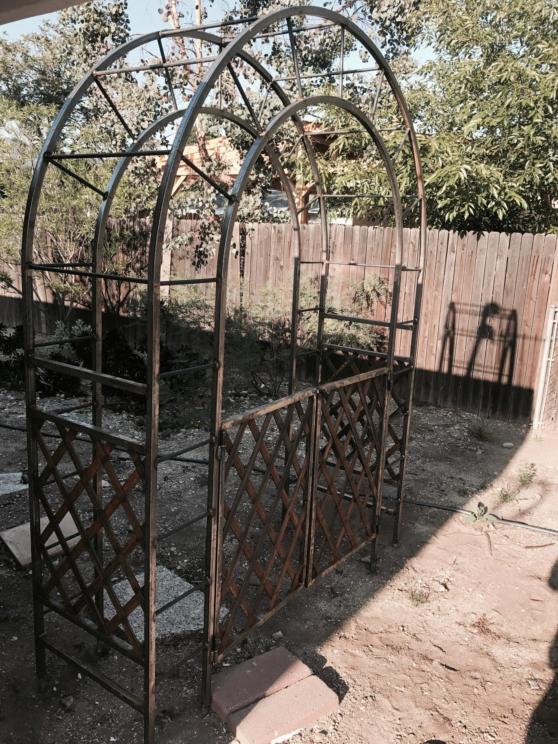 Custom raw steel garden arbor with arched lattice gate