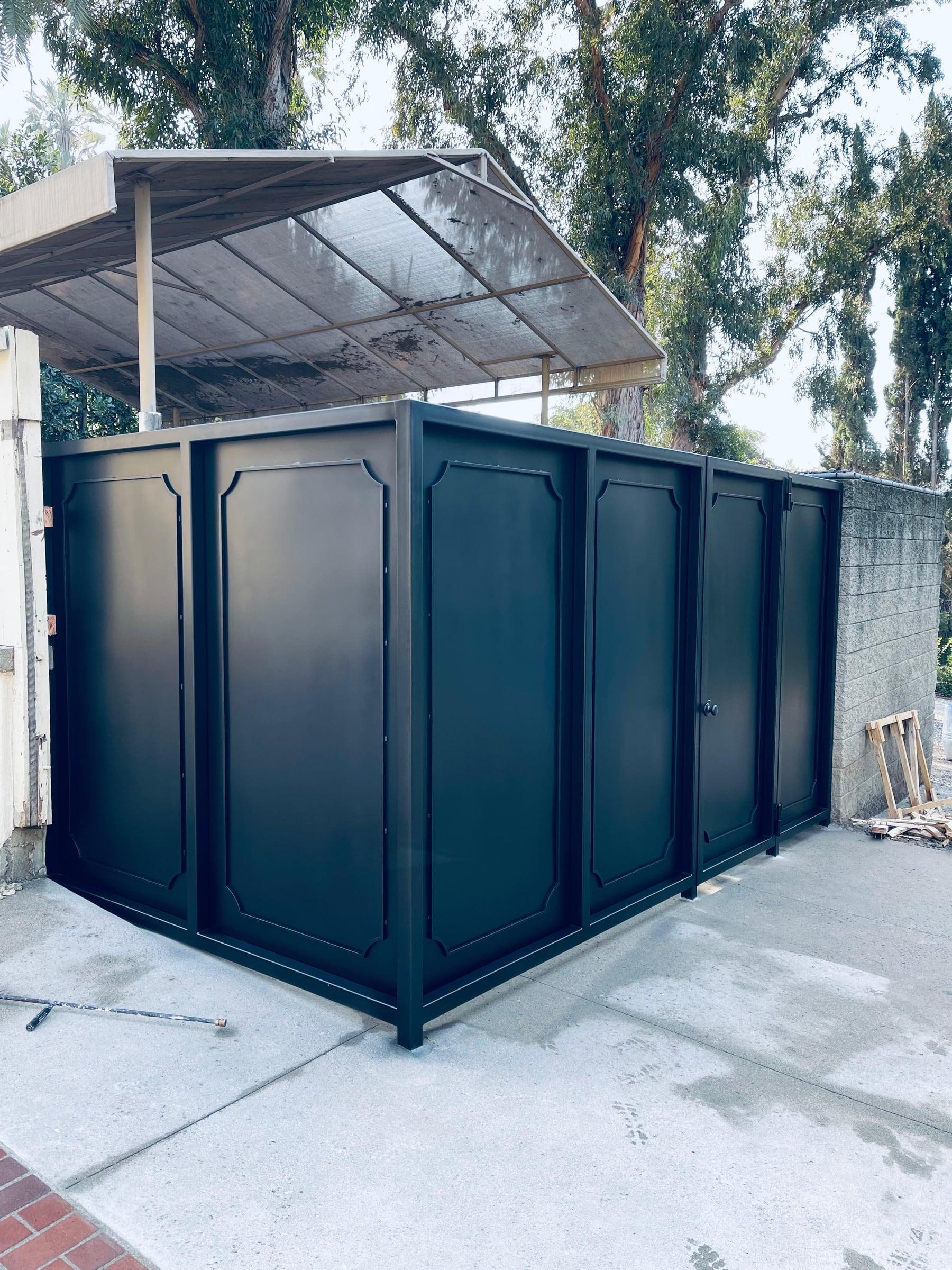 Custom dark metal storage enclosure with paneled doors viewed from the side