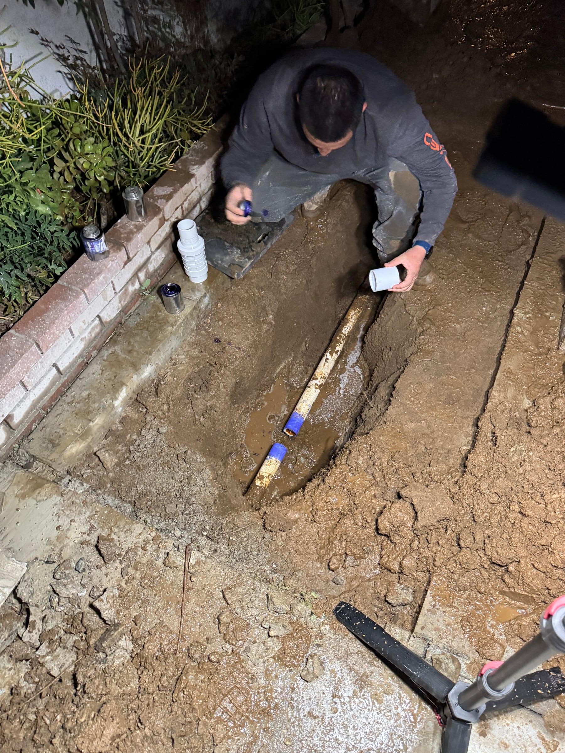 Gluing PVC irrigation pipe fittings in an open trench