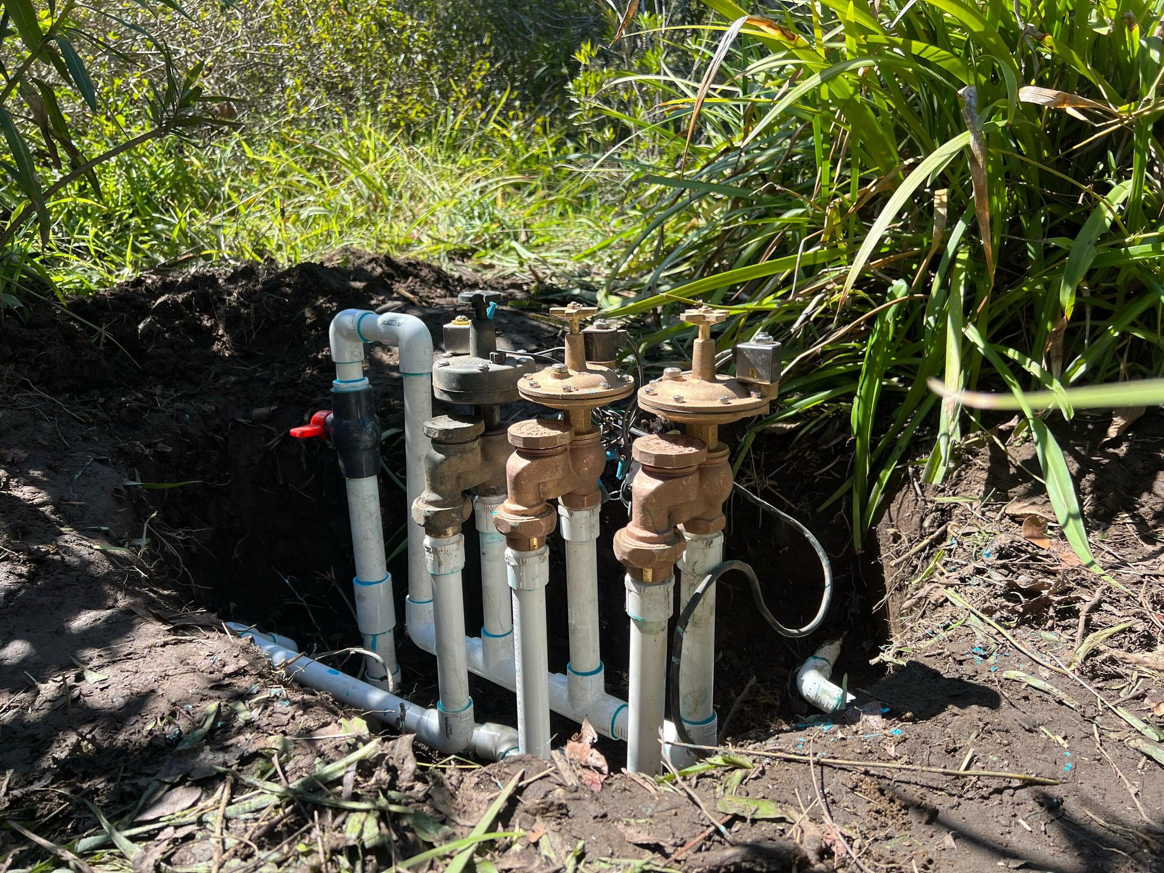 Exposed manifold of brass anti-siphon valves and PVC piping
