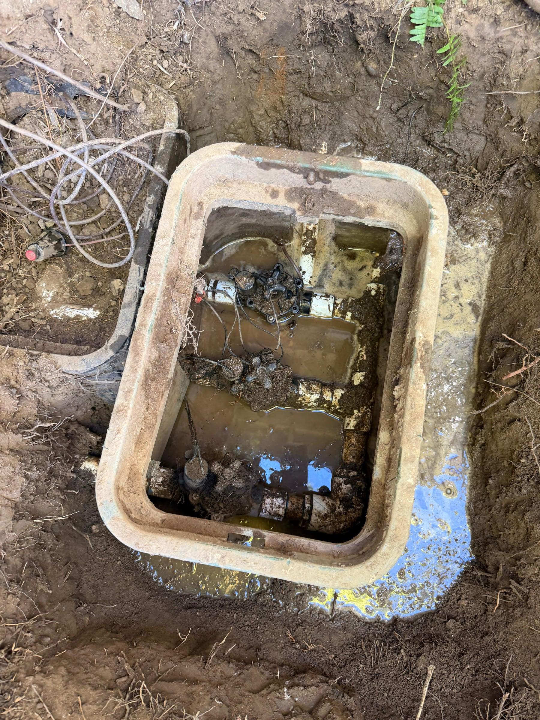 Open irrigation valve box exposing an aging valve manifold