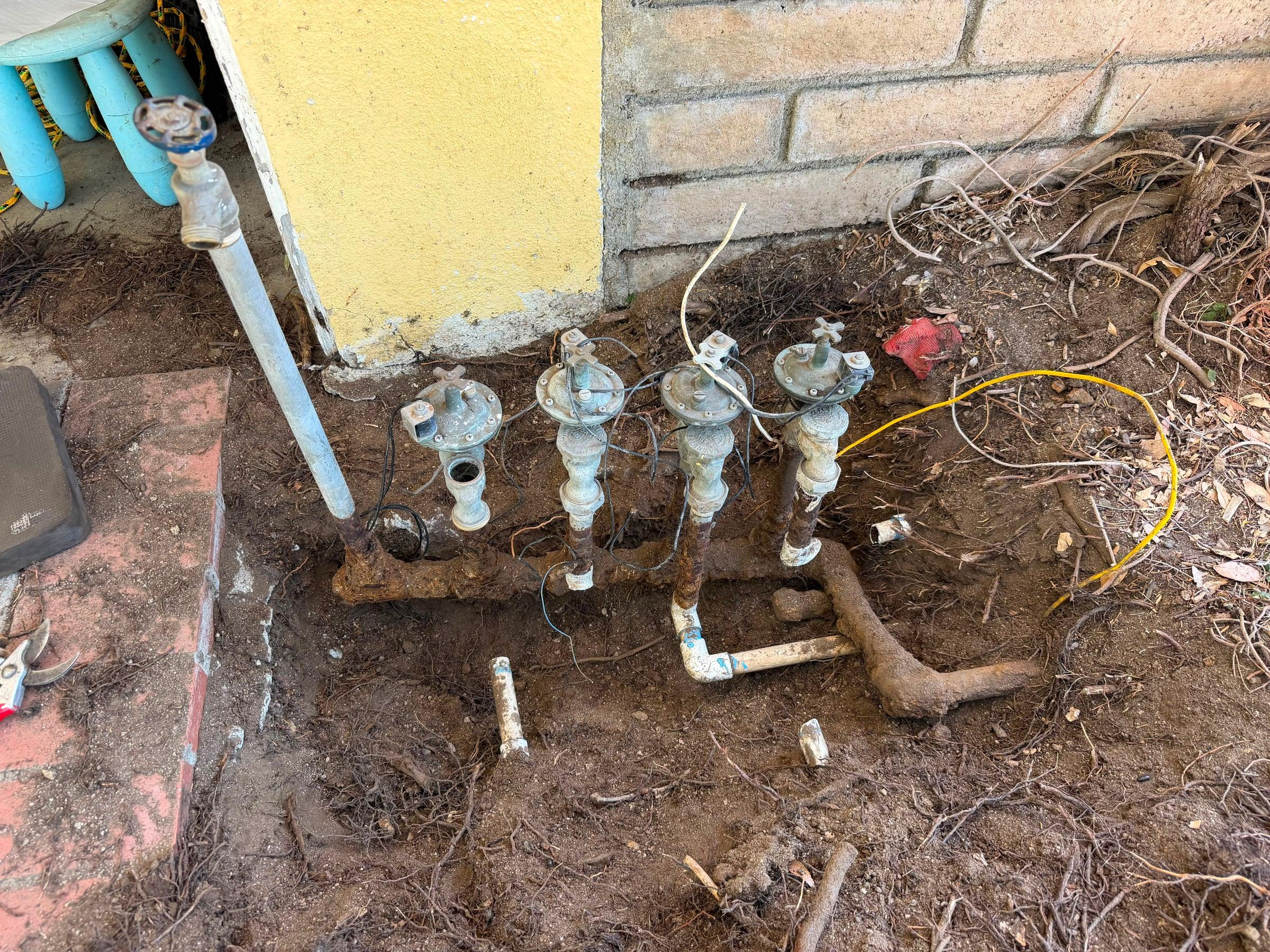 New irrigation valves being installed near an aging manifold