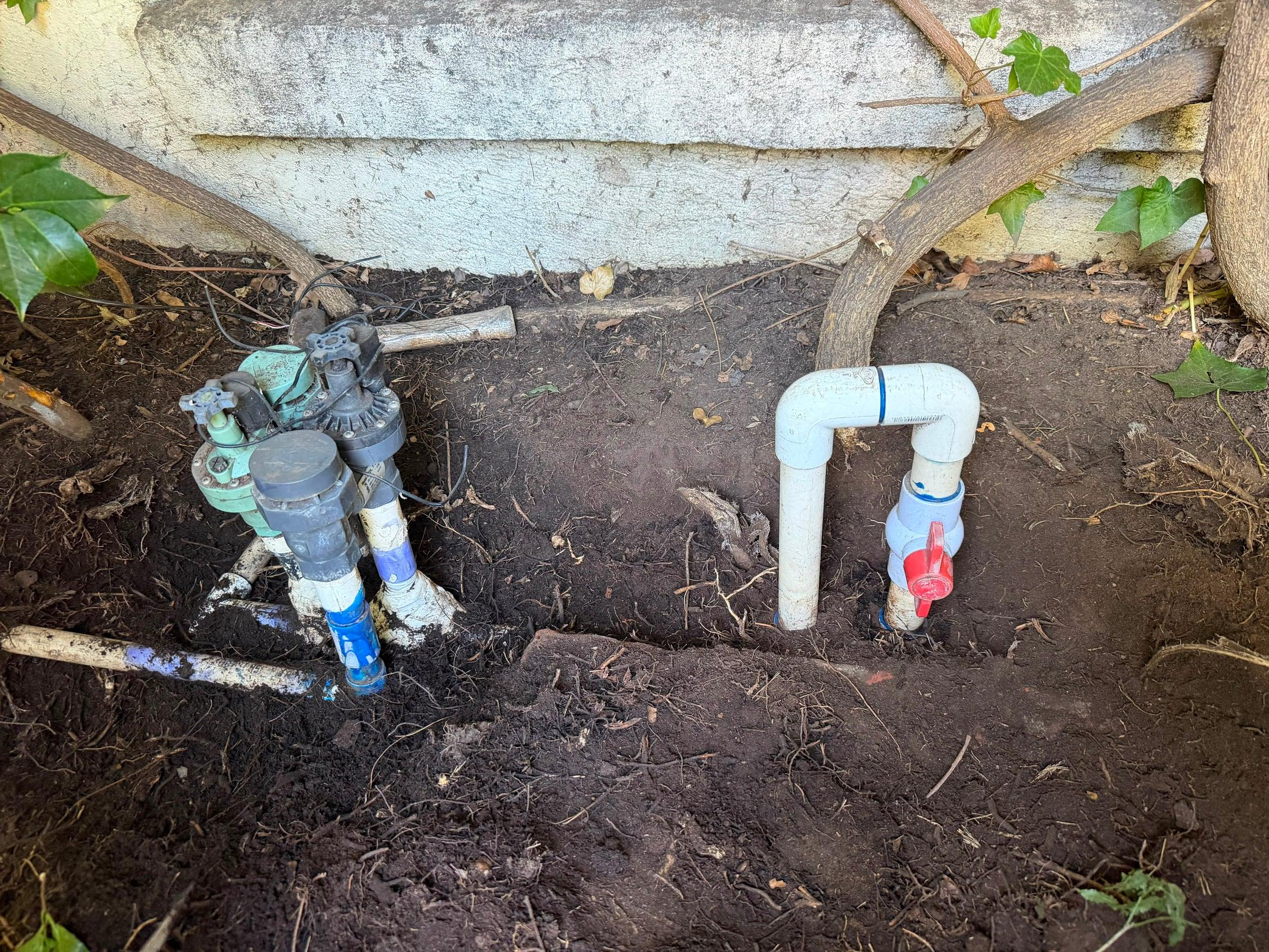 New irrigation piping connected along a side yard wall