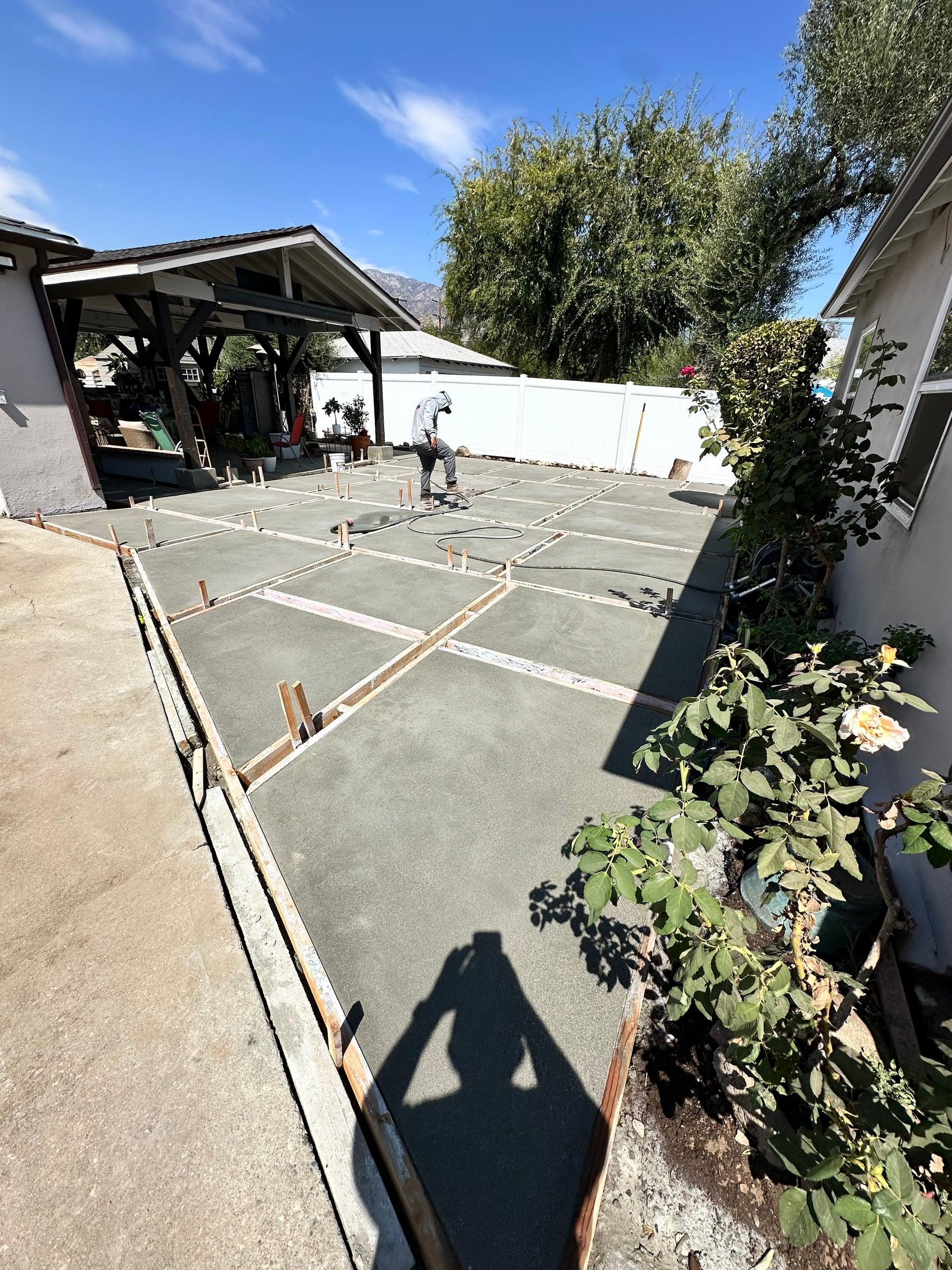 New concrete patio slab being finished with control joints