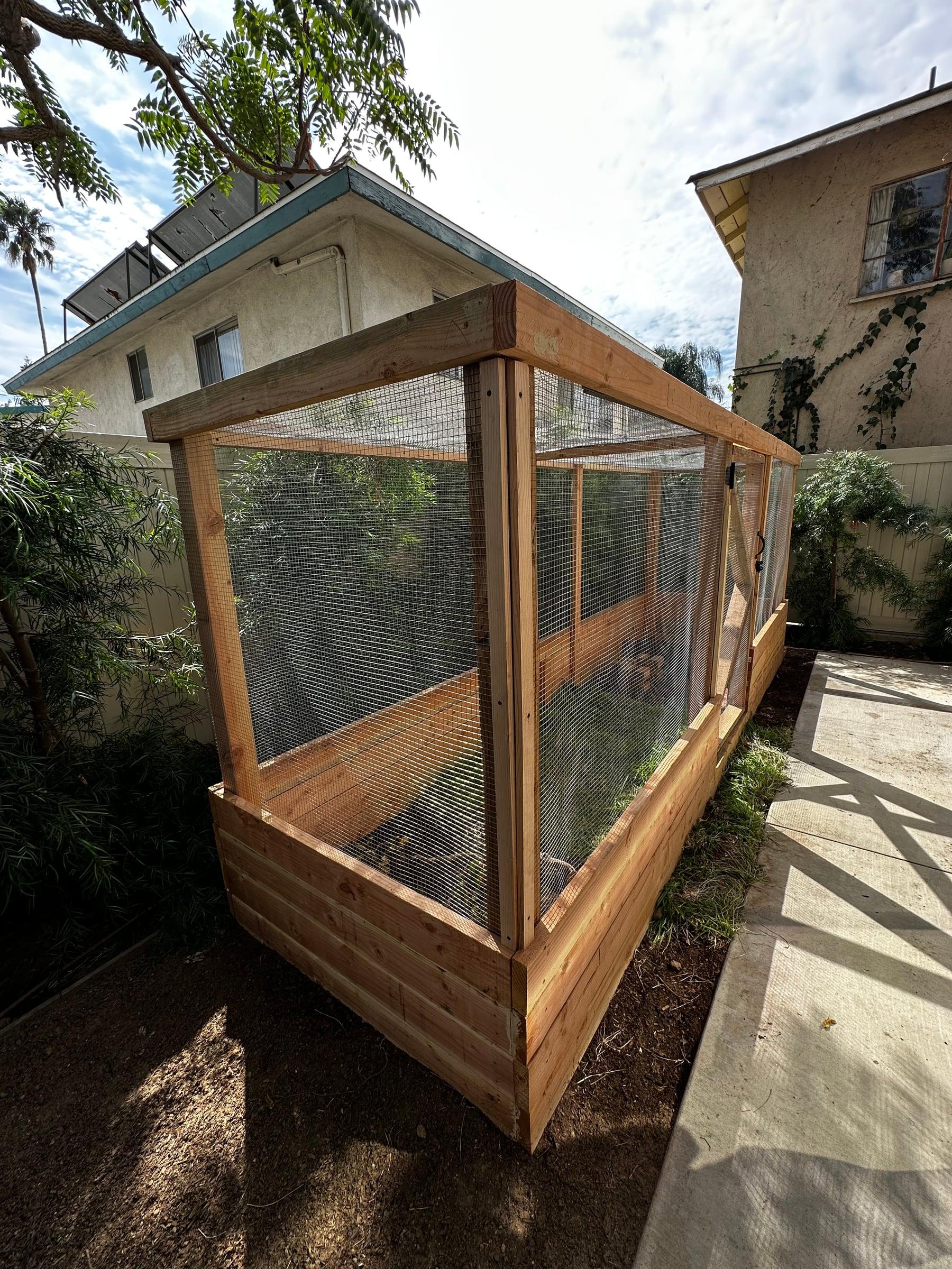 Custom redwood screened enclosure with a wire mesh gate