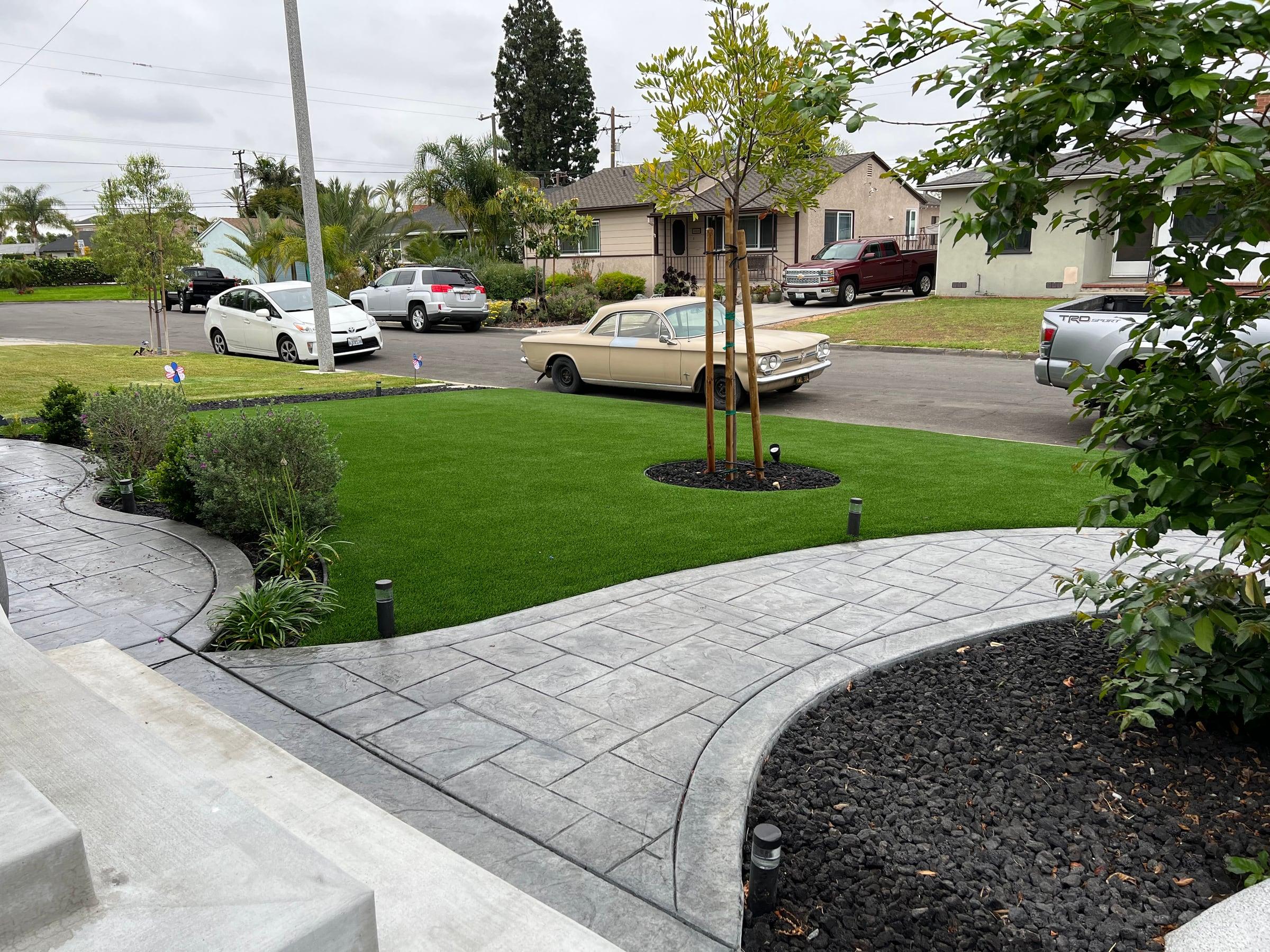 Front yard with new artificial turf and a stamped concrete walkway