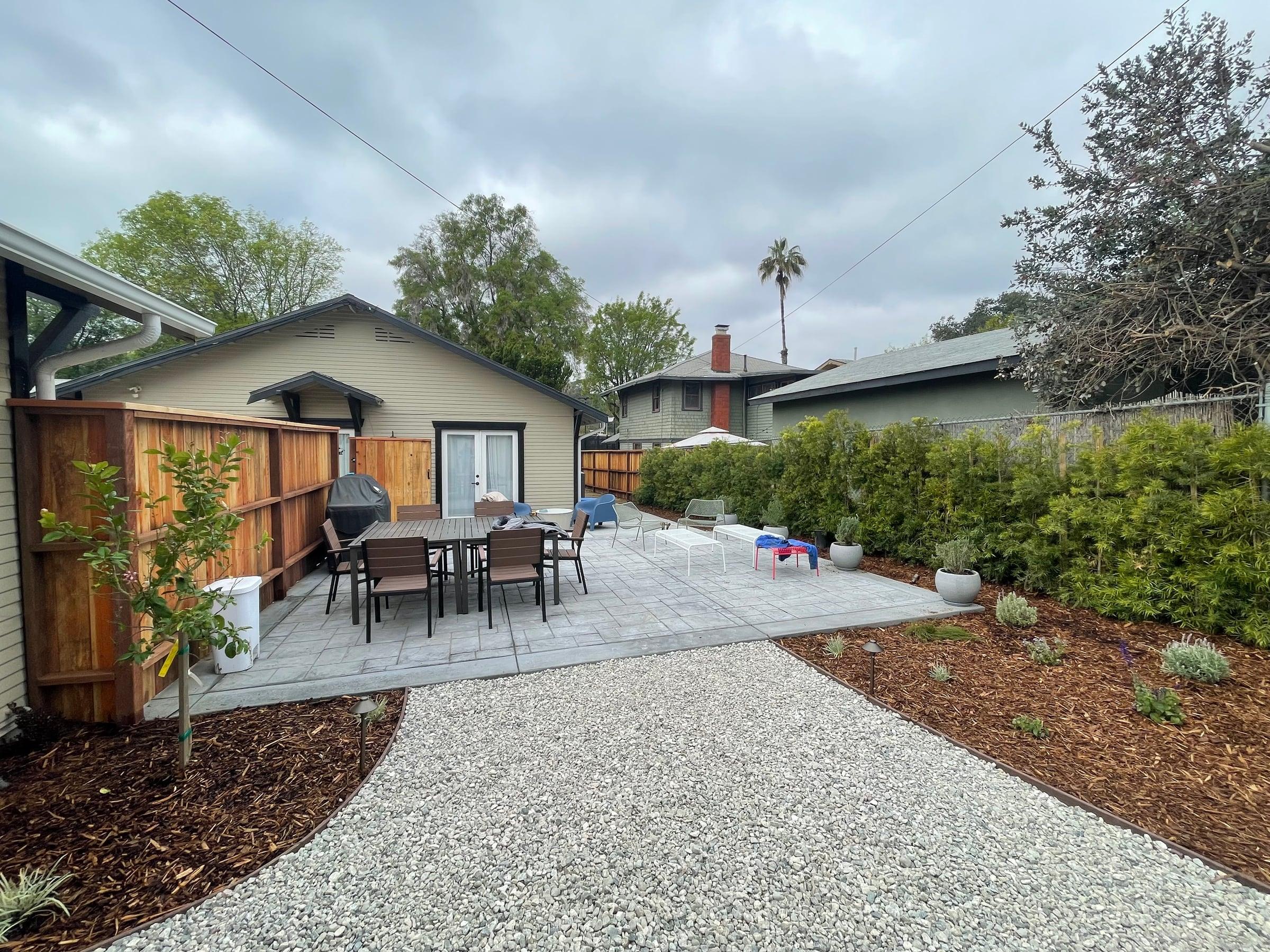 Backyard patio with dining set and a trimmed privet hedge
