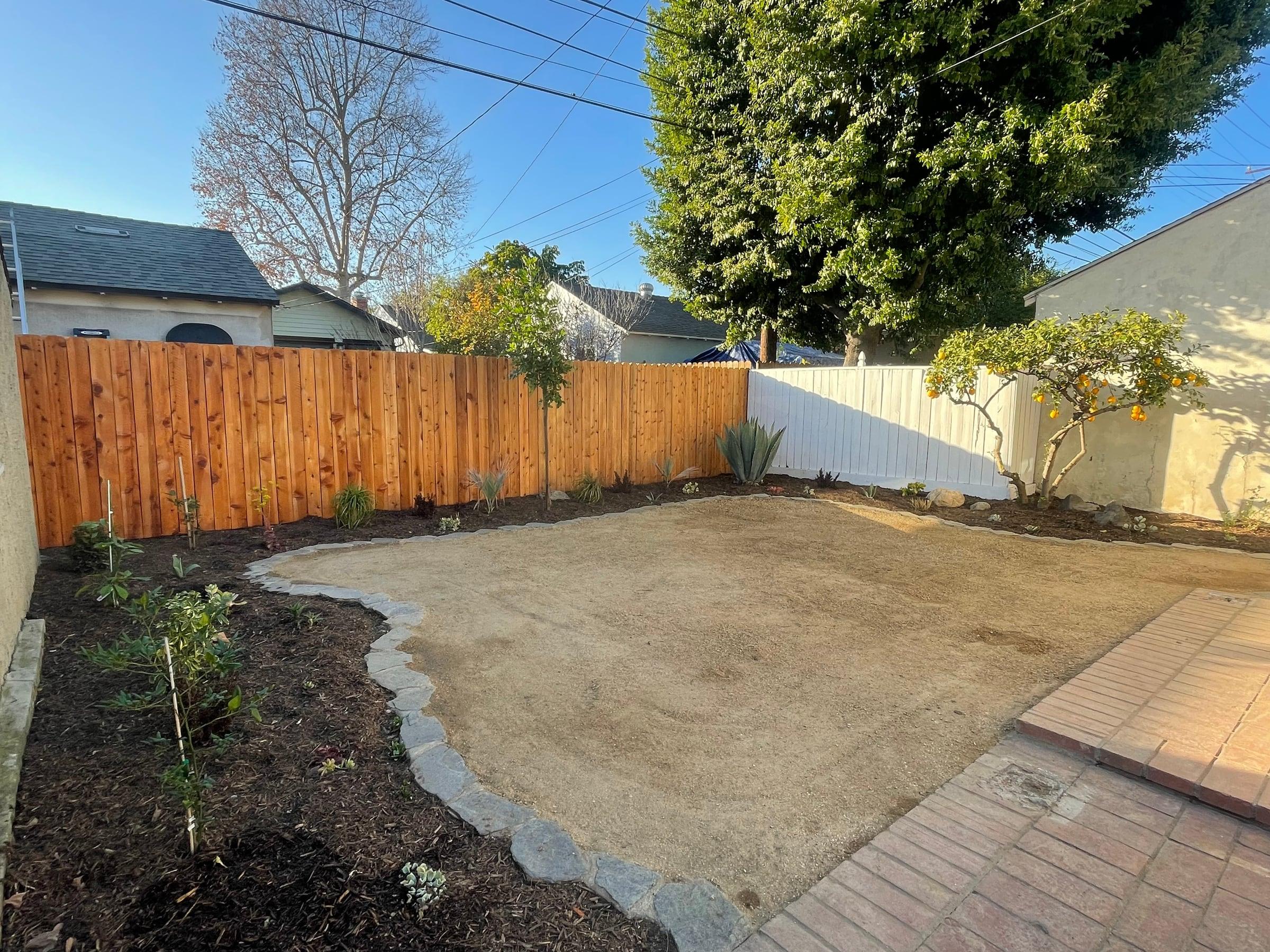 Decomposed granite patio pad with a stone border and paver walkway